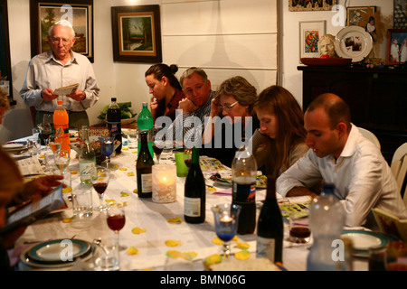 Famille assis autour d'une table pour un repas de fête juive sur la Pâque Seder Banque D'Images