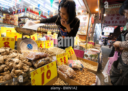 Les clients qui achètent des aliments secs, les graines, les noix et autres trucs en magasin à Hong Kong Banque D'Images