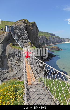 Marchant sur Carrick-a-rede, Ballintoy, comté d'Antrim, en Irlande du Nord Banque D'Images