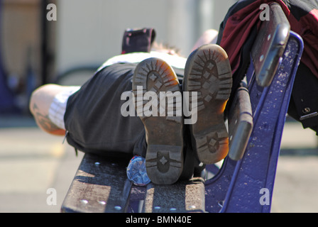 Un homme dort sur un banc à Exteter gare St Davids, UK Banque D'Images