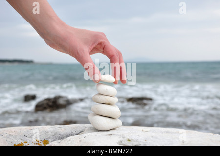 L'empilement des pierres sur la plage femme Croatie Medulin Banque D'Images