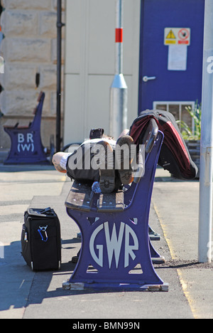 Un homme dort sur un banc à Exteter gare St Davids, UK Banque D'Images