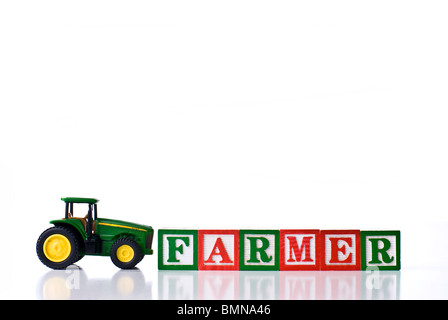 Enfants colorés blocks spelling agriculteur avec un tracteur Banque D'Images