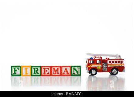 Enfants colorés blocks spelling pompier avec un camion d'incendie Banque D'Images