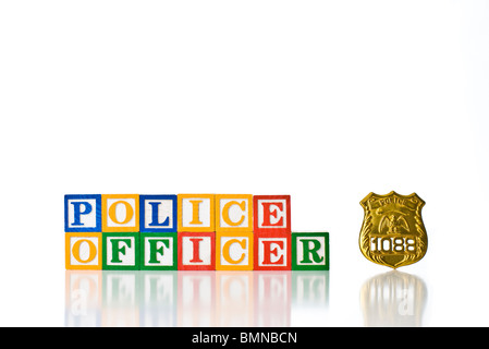 Enfants colorés blocks spelling AGENT DE POLICE avec un insigne Banque D'Images