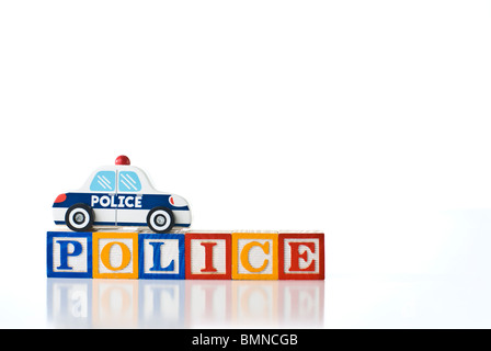 Blocs d'enfants colorés de la police de l'orthographe avec un jouet voiture de police Banque D'Images