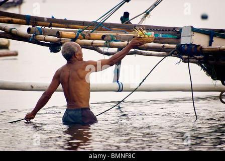 Sur le jour saint de l'hindouisme balinais Kuningan, la population du village d'apporter des offrandes de Pemuteran pour les bateaux de pêche. Banque D'Images