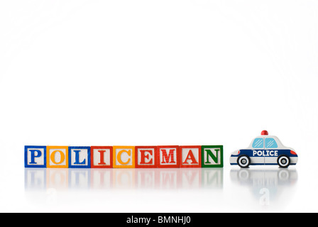 Enfants colorés blocks spelling POLICKEMAN avec un jouet voiture de police Banque D'Images