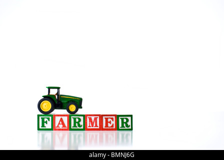 Enfants colorés blocks spelling agriculteur avec un tracteur Banque D'Images