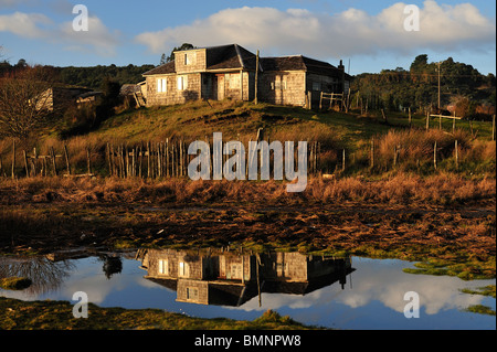 Maison solitaire en miroir de l'étang à Chiloé au sud chili Banque D'Images