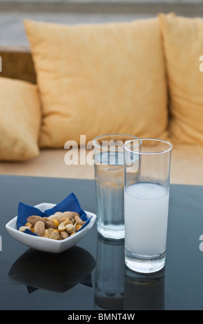 Verre d'Ouzo, l'eau et des collations sur une table de café à Skopelos, Grèce Banque D'Images
