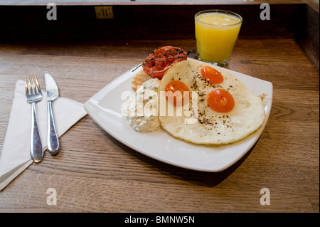 Trois oeufs de caille au plat à la tomate frite pour le petit-déjeuner. Banque D'Images