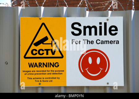 Panneau d'avertissement de vidéosurveillance avec 'smile humoristiques pour l'appareil photo" graphique. Sur une clôture à Manchester, Angleterre, RU Banque D'Images