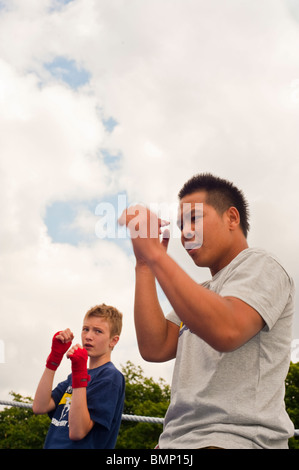 « The Thai Festival London », Asian Festival, Royaume-Uni, instructeur de boxe thaï avec jeune élève masculin montrant les garçons de l'adolescence traditionnels qui se battent Banque D'Images