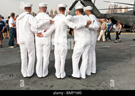 Cinq jeunes marins en tenue pour les visiteurs posent les blancs au poste de pilotage de l'USS Iwo Jima lors de la Fleet Week à New York Banque D'Images