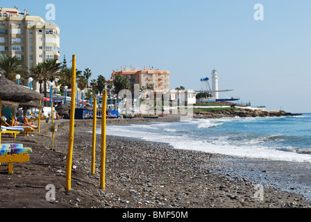 Parasol jaune poteaux sur la plage, à Torrox Costa, Costa del Sol, la province de Malaga, Andalousie, Espagne, Europe de l'Ouest. Banque D'Images