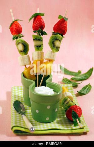 Brochettes de fruits avec du yogourt. Recette disponible. Banque D'Images