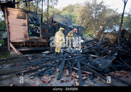 Pompiers inspecter les décombres après l'incendie. Banque D'Images