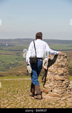 UK, Derbyshire Peak District, plus âgés, Walker se reposant à Mam Tor point sommet trig Banque D'Images