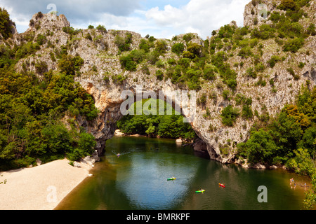 Canoë au-dessous de la voûte en pierre naturelle Pont d'arc sur la rivière Ardèche Banque D'Images