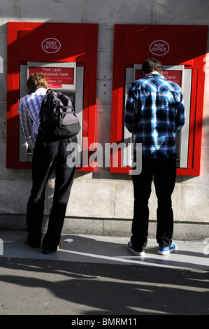 UK- Clients dimensions argent au distributeur de billets à l'extérieur du bureau de poste Banque D'Images