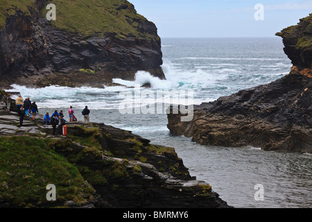 Visiteurs regardant des vagues se brisant sur les rochers à Boscastle, Cornwall, Angleterre Banque D'Images