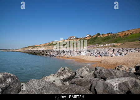 Falaise et maisons en pierre de roche les défenses maritimes épis à Barton sur mer Banque D'Images