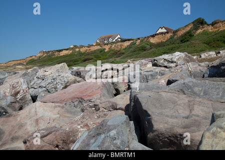 Bâtiments sur le bord de la falaise à Barton sur Mer à Hampshire en danger de tomber dans la mer en raison de l'érosion côtière Banque D'Images