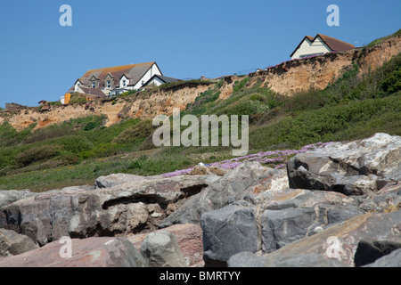 Bâtiments sur le bord de la falaise à Barton sur Mer à Hampshire en danger de tomber dans la mer en raison de l'érosion côtière Banque D'Images