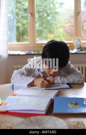 Garçon de huit ans fait ses devoirs. Banque D'Images