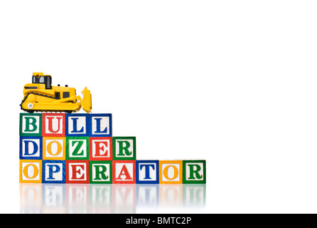 Enfants colorés blocks spelling Bull Dozer opérateur à l'aide d'un bulldozer modèle Banque D'Images