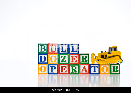 Enfants colorés blocks spelling Bull Dozer opérateur à l'aide d'un bulldozer modèle Banque D'Images