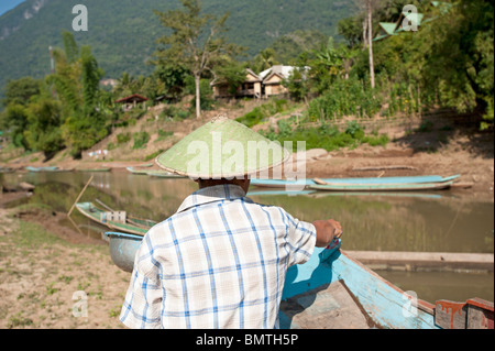 Ajo man painting un canoë à Muang Ngoi du nord du Laos Banque D'Images