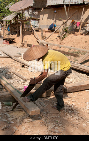 Un homme d'ajo scier du bois dans un village tribal de Vong Xai province du nord du Laos Banque D'Images