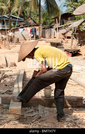 Un homme d'ajo scier du bois dans un village tribal de Vong Xai province du nord du Laos Banque D'Images