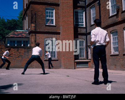 Harrow School des années 1980. Les garçons à jouer au cricket dans une maison cour. Banque D'Images