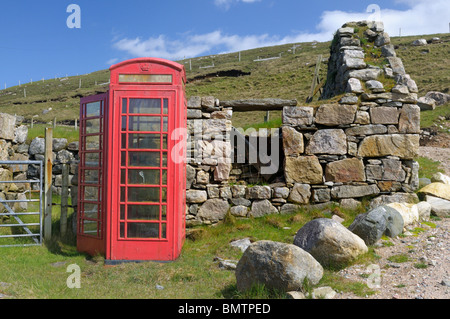 Old style red UK téléphone fort à côté d'une épave croft house Banque D'Images