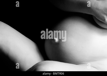Image shadowfull artistique d'un ventre de femme enceinte. Faites en studio sur fond noir avec un Canon 5D Banque D'Images