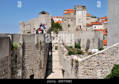 Les touristes en ordre décroissant les étapes sur le mur extérieur de l'appartement donne sur les personnes utilisant l'escalier à l'intérieur de la vieille ville de Dubrovnik Banque D'Images