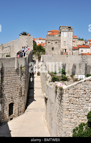 Les touristes en ordre décroissant les étapes sur le mur extérieur de l'appartement donne sur les personnes utilisant l'escalier à l'intérieur de la vieille ville de Dubrovnik Banque D'Images