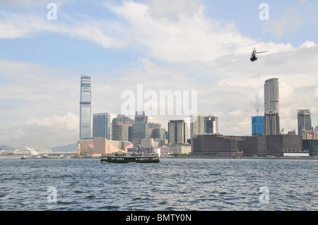 Star Ferry traversant le port de Victoria, à l'hélicoptère, contre une toile de gratte-ciel de Tsim Sha Tsui, Kowloon, Hong Kong Banque D'Images