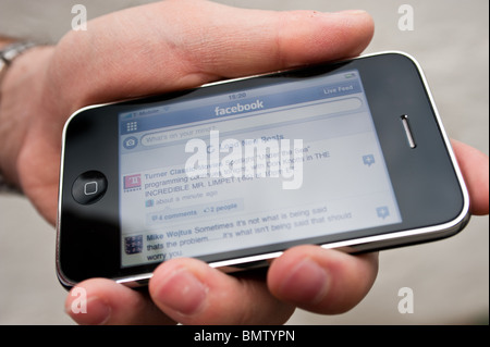 L'accès à Facebook sur un iPhone Banque D'Images