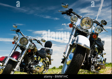 Motocyclettes Harley Davidson dans un champ contre le bleu de ciel nuageux en Angleterre Banque D'Images