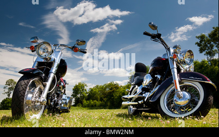 Motocyclettes Harley Davidson dans un champ contre le bleu de ciel nuageux en Angleterre Banque D'Images