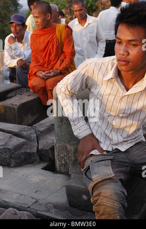 Un jeune homme cambodgien jouit de la vue du coucher de soleil au large de Wat Phnom Bakeng à Angkor, Cambodge Banque D'Images