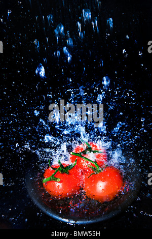 Les tomates fraîches sous le robinet avec de l'eau gouttes Banque D'Images