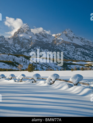 Parc National de Grand Teton, Wyoming enneigés des ligne de clôture avec les sommets de la chaîne Teton dans la lumière d'hiver Banque D'Images