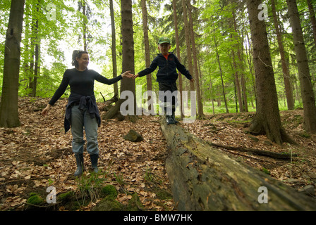 Les enfants à la découverte de la forêt - les garçons jouent à l'extérieur. Mother helping son tronc plus Banque D'Images