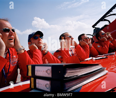 Les pilotes 'flèches' rouge, la Royal Air Force britannique aerobatic team block oreilles pendant exposé pré-vol avant l'affichage. Banque D'Images