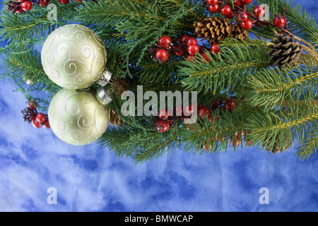 Défilement d'or Boule de Noël avec des branches de sapin, pin, rouge des baies de houx, réflexions et copyspace Banque D'Images